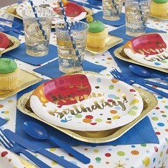 Bambini e decorazioni di compleanno. ragazzi e ragazze a tavola con cibo,  dolci, bevande e gadget per le feste.